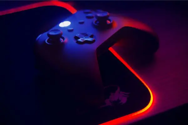 A high-end gaming controller illuminated by red and blue neon lights, symbolizing professional localization expertise for AAA, mobile, and indie game titles.
