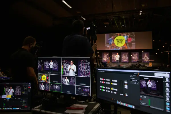 A modern media control room with multiple screens managing the distribution for global creative localization across different platforms.
