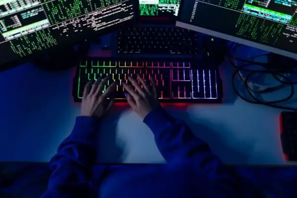 A technical localization expert working on multiple monitors with code and game interfaces, illustrating the professional QA testing and end-to-end localization process for global game releases.