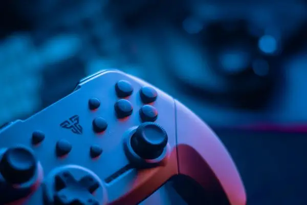 Close-up of a modern video game controller with neon lighting, representing UI/UX adaptation and multilingual game text translation services.